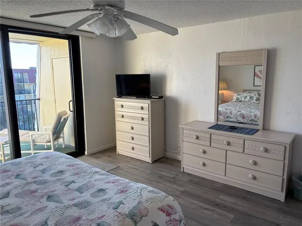 a bedroom with a bed and a mirror on dresser