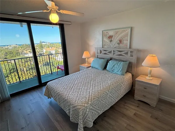 a bedroom with a large bed and a flat tv screen