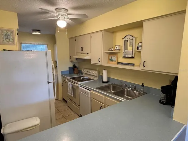 a kitchen with stainless steel appliances a sink a stove a refrigerator and cabinets