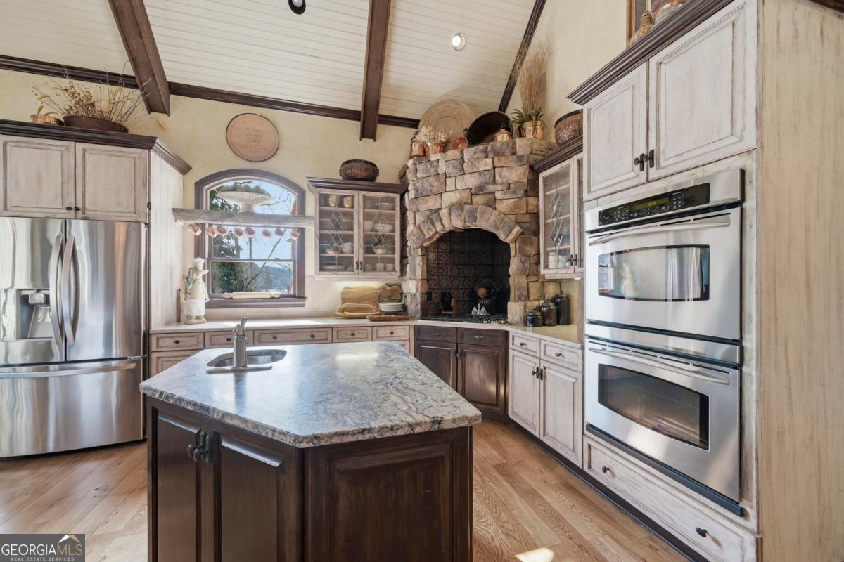 1691 Lighthouse Circle Greensboro, GA 30642 - Photo 20 of 75 a kitchen with granite countertop stainless steel appliances a stove microwave and refrigerator
