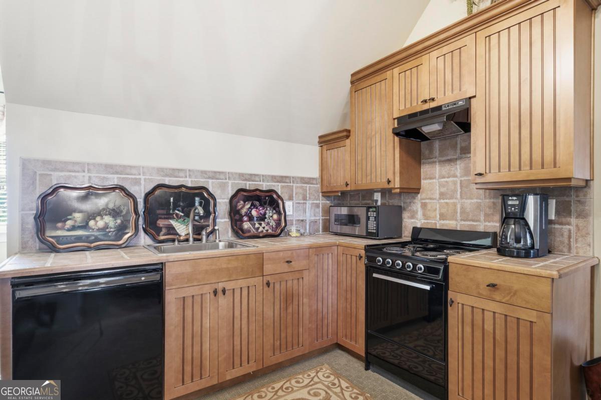 1691 Lighthouse Circle Greensboro, GA 30642 - Photo 41 of 75 a kitchen with stainless steel appliances granite countertop a stove a sink and a microwave