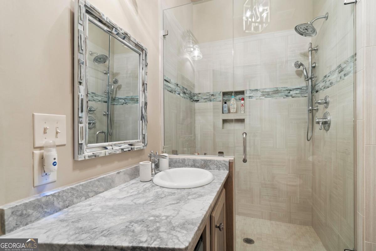 1691 Lighthouse Circle Greensboro, GA 30642 - Photo 49 of 75 a bathroom with a granite countertop sink a shower and a mirror