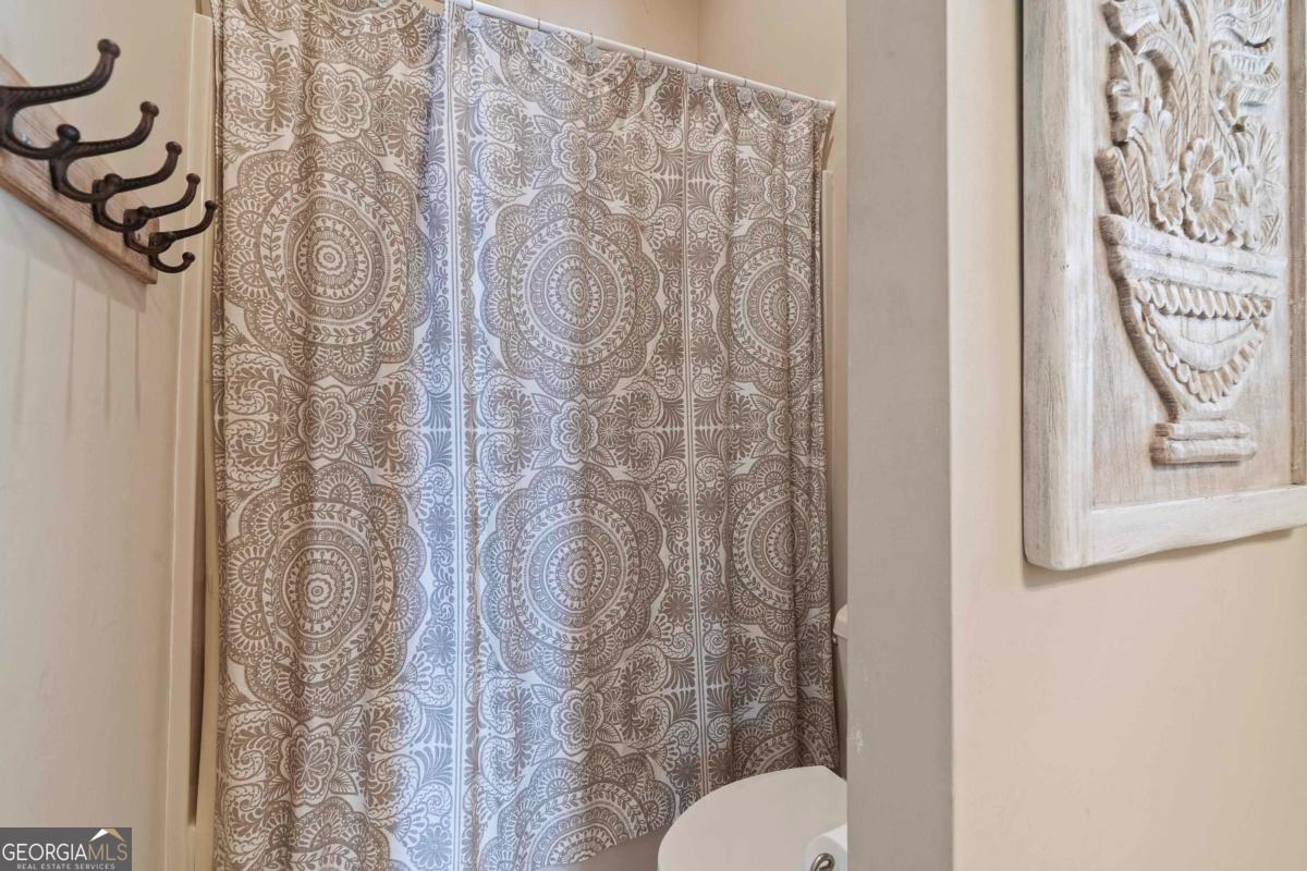 1691 Lighthouse Circle Greensboro, GA 30642 - Photo 55 of 75 a bathroom with a toilet and a shower curtain