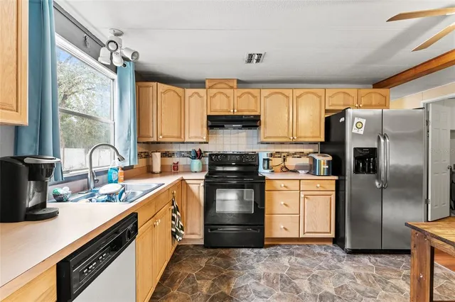 a kitchen with stainless steel appliances a refrigerator sink and cabinets