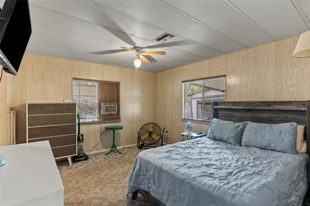 a bedroom with a bed and a flat tv screen on dresser