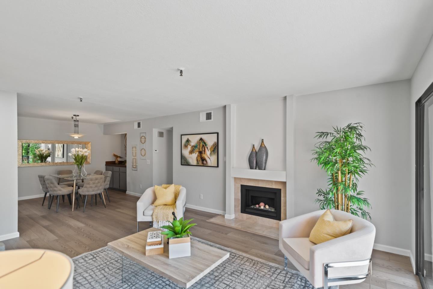 49 Showers Drive, Unit E250 Mountain View, CA 94040 - Photo 4 of 27 a living room with furniture a potted plant and a fireplace
