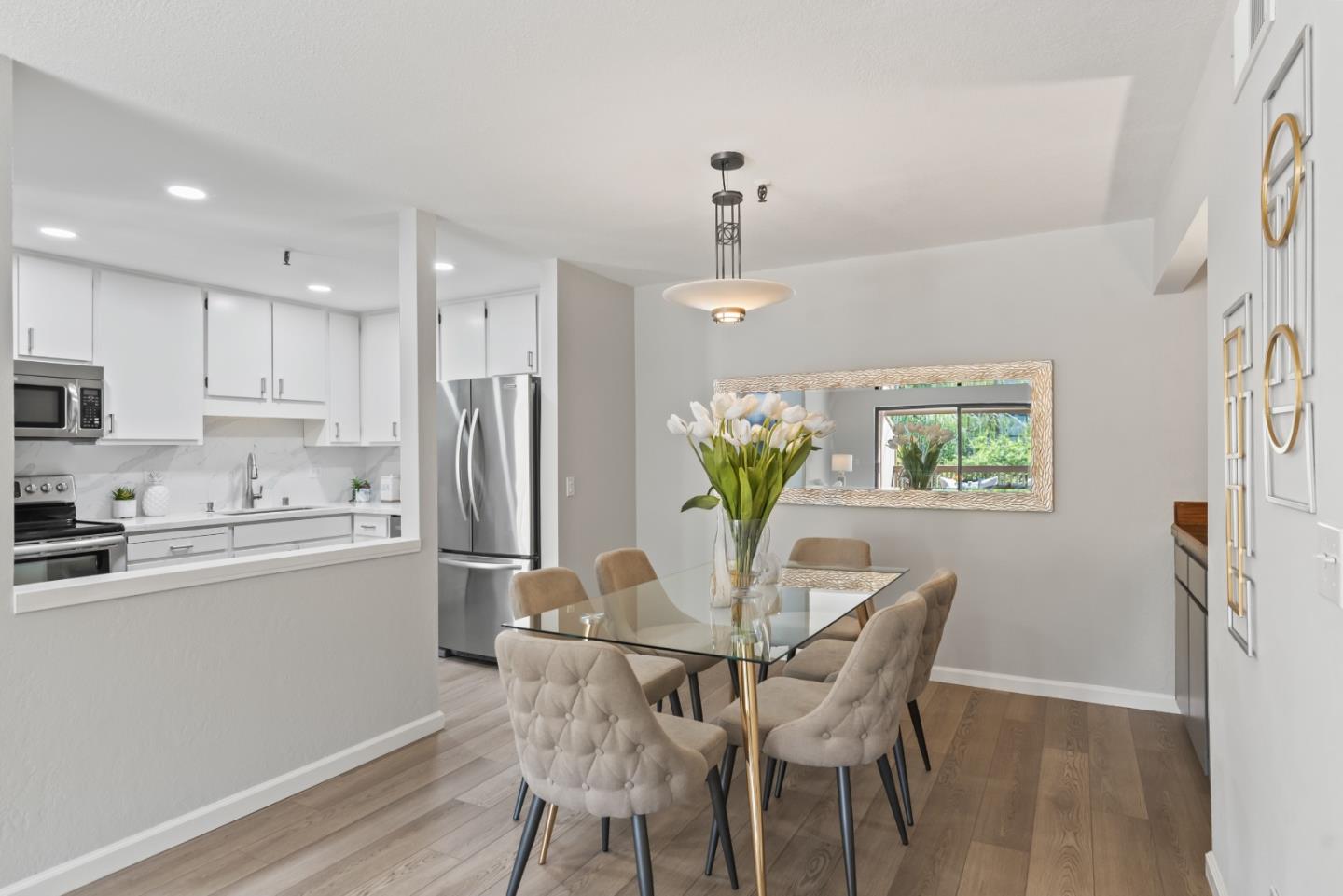 49 Showers Drive, Unit E250 Mountain View, CA 94040 - Photo 7 of 27 a kitchen with stainless steel appliances a dining table chairs and wooden floor