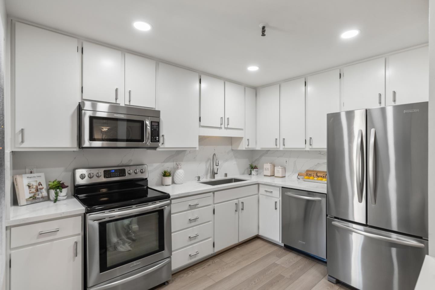49 Showers Drive, Unit E250 Mountain View, CA 94040 - Photo 9 of 27 a kitchen with stainless steel appliances a refrigerator sink and microwave