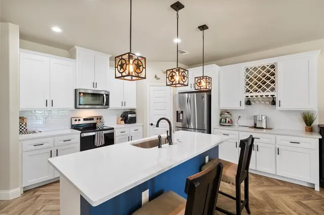 a kitchen with stainless steel appliances granite countertop a sink a stove and a center island