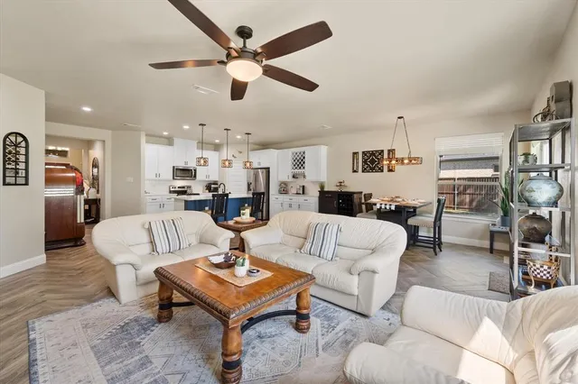 a living room with furniture kitchen view and a window