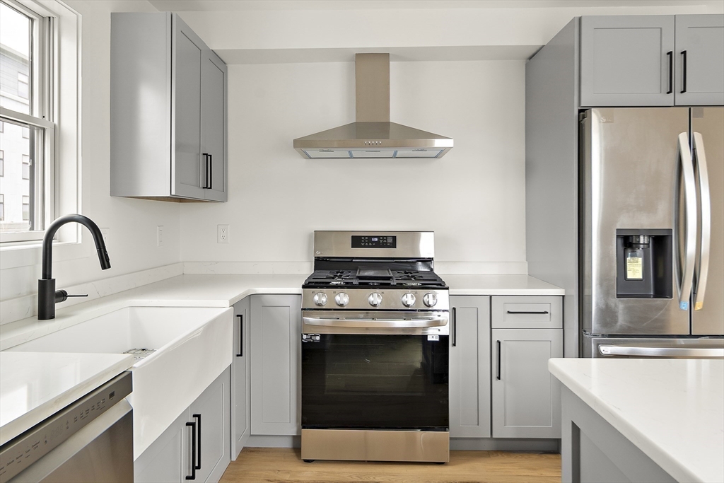 25 Hillsboro Street, Unit 1 Boston, MA 02125 - Photo 4 of 14 a kitchen with stainless steel appliances a stove a sink and a refrigerator