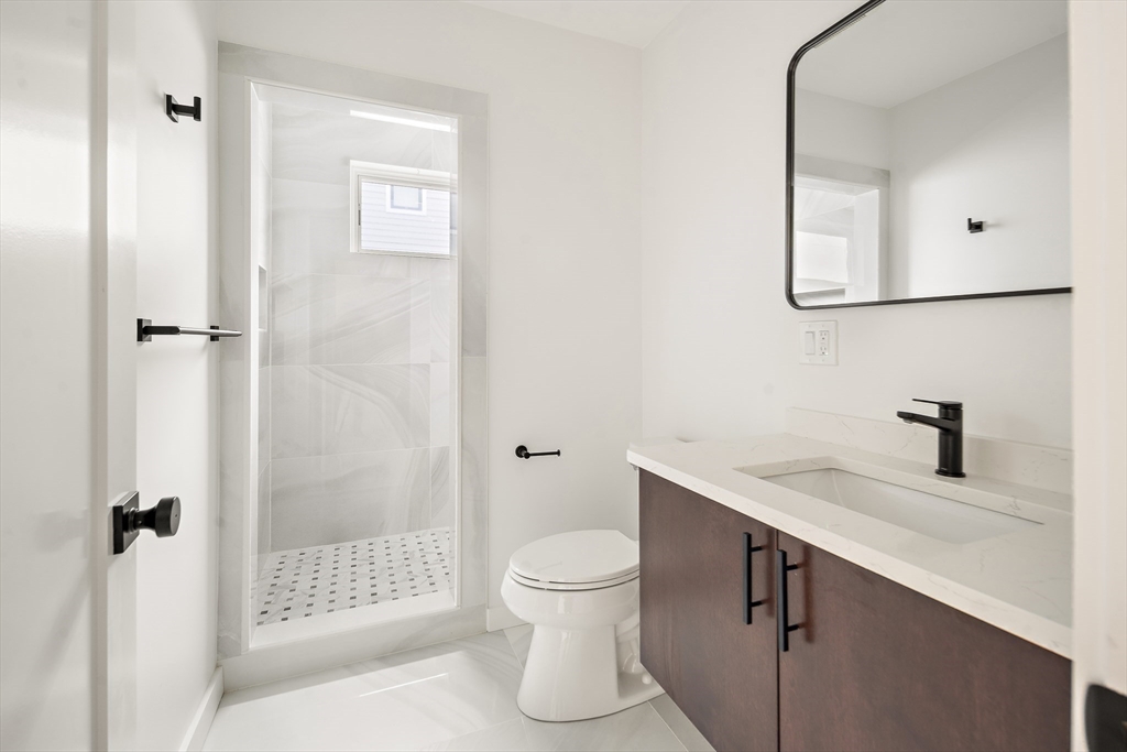 25 Hillsboro Street, Unit 1 Boston, MA 02125 - Photo 8 of 14 a bathroom with a granite countertop sink toilet and shower