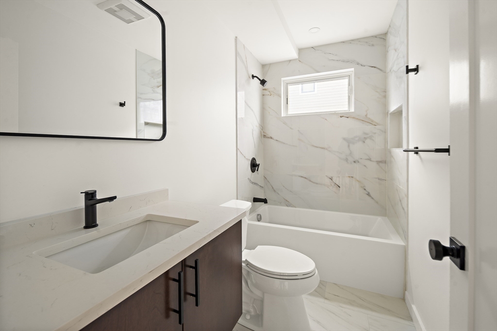 25 Hillsboro Street, Unit 1 Boston, MA 02125 - Photo 9 of 14 a bathroom with a sink a toilet and shower