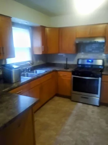 a kitchen with stainless steel appliances granite countertop a stove a sink and a microwave