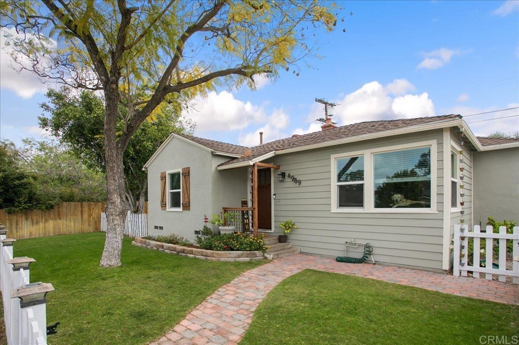 a front view of a house with a yard and potted plants