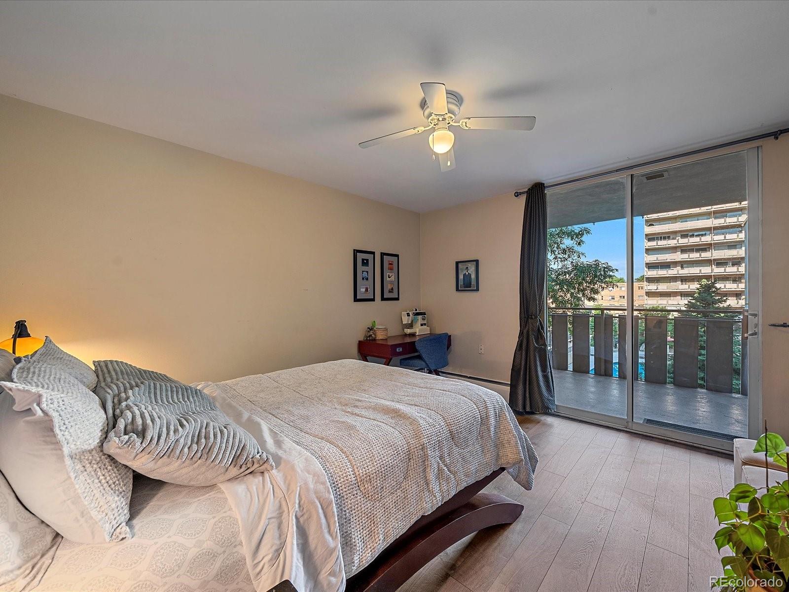1111 Ash Street, Unit 307 Denver, CO 80220 - Photo 14 of 21 a bedroom with a large bed and a chandelier