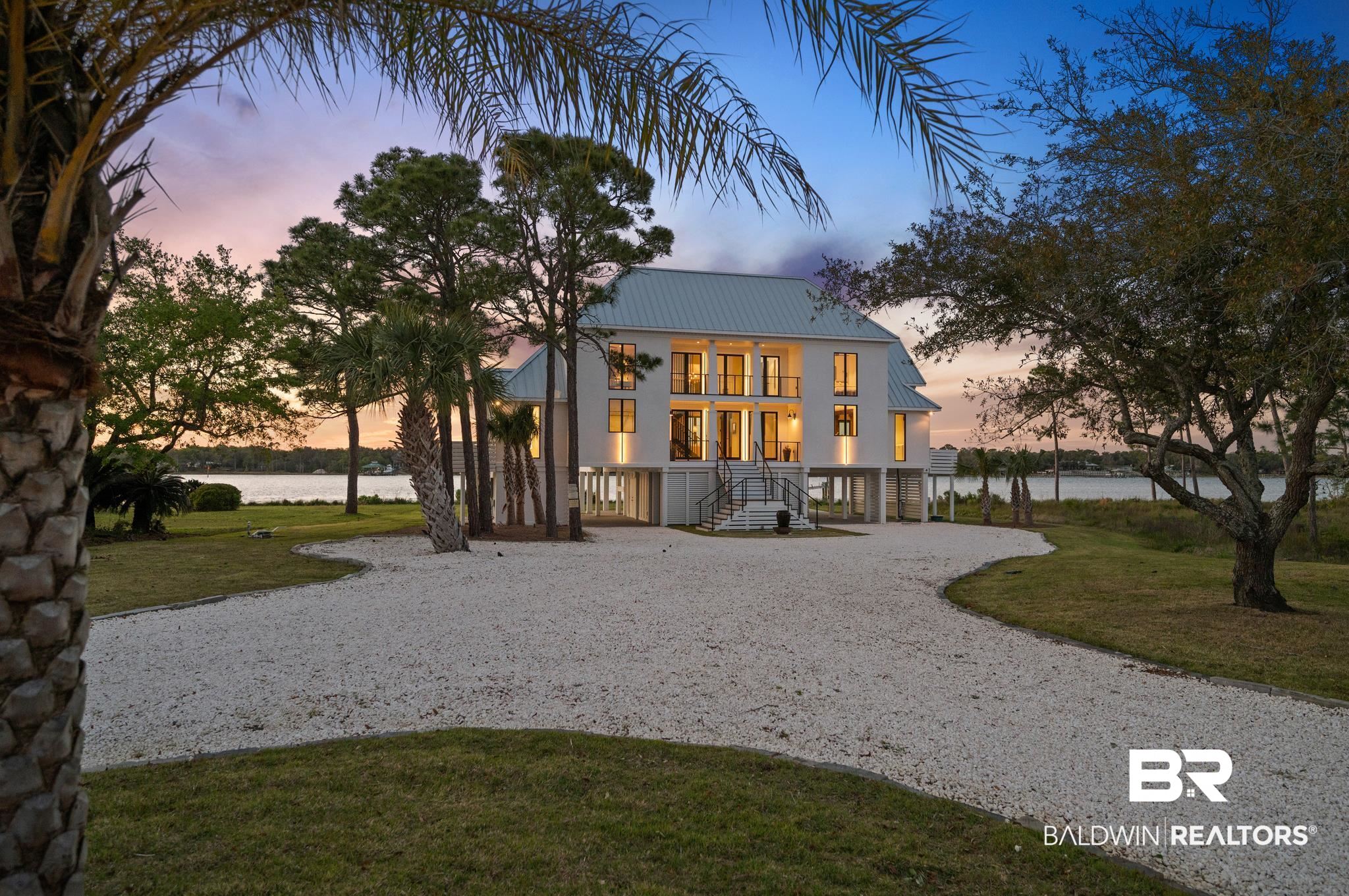 33349 River Road Orange Beach, AL 36561 - Photo 58 of 61 Stilted coastal residence featuring a light-colored metal roof and multiple exterior balconies