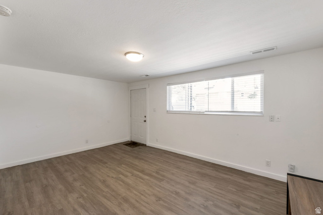434 South 700 West, Unit 2 Provo, UT 84601 - Photo 4 of 15 Spacious room featuring wood-finish flooring, white baseboards, and a neutral wall palette