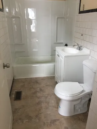 a white toilet sitting next to a bathroom sink and tub