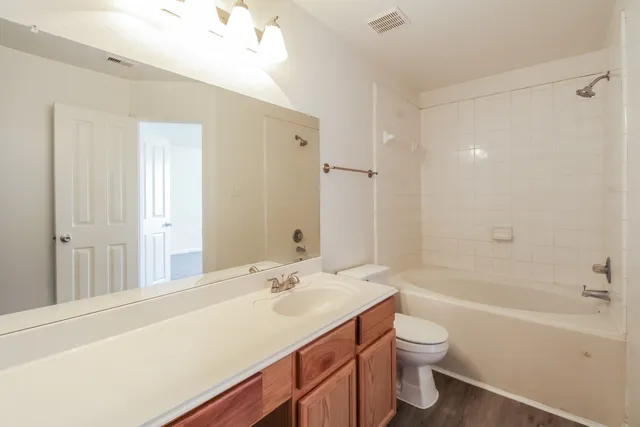 a bathroom with a sink a toilet a large mirror and shower