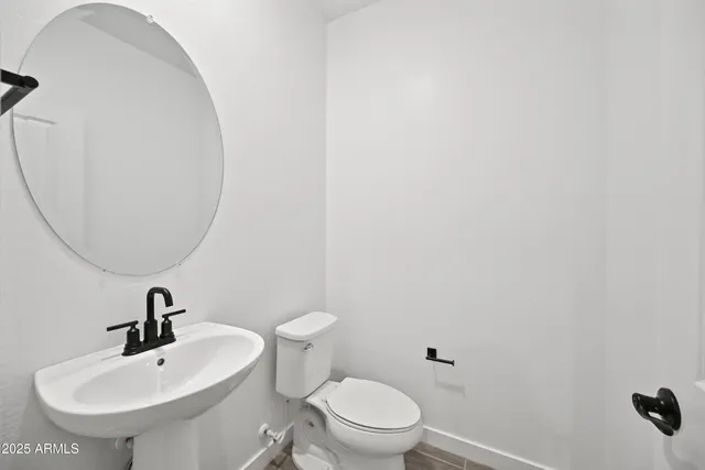 a bathroom with a toilet a sink and mirror