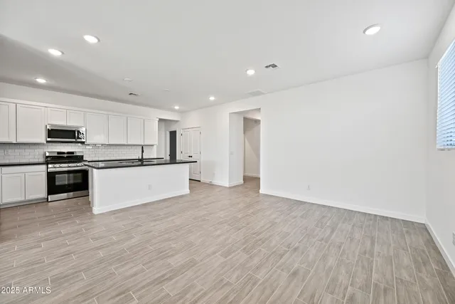 a kitchen with stainless steel appliances granite countertop a refrigerator and a stove top oven