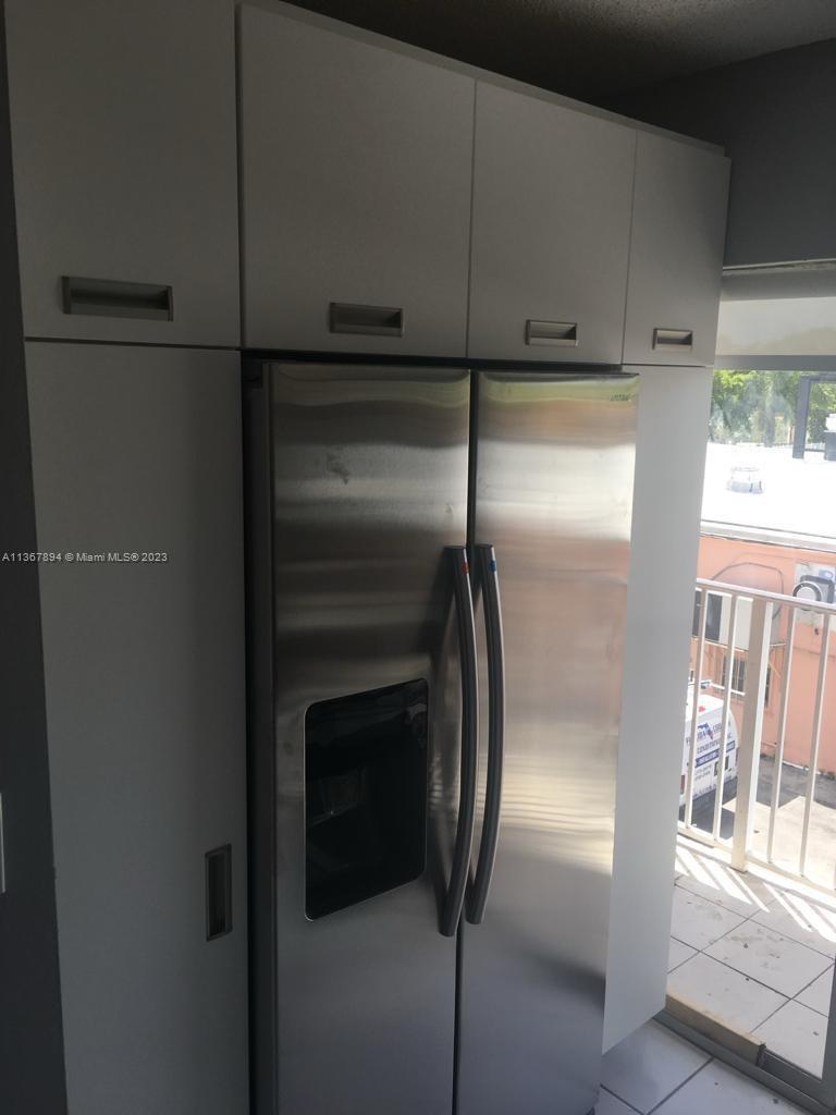 1852 Southwest 7th Street, Unit 309 Miami, FL 33135 - Photo 5 of 12 a metallic refrigerator freezer sitting in a kitchen