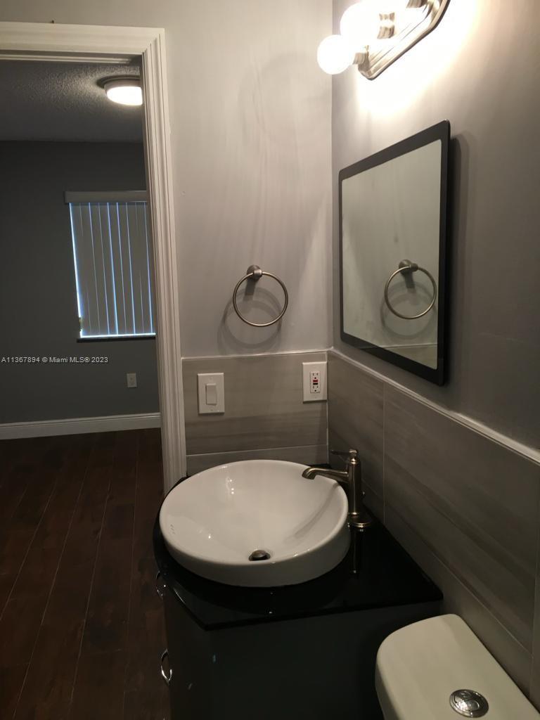 1852 Southwest 7th Street, Unit 309 Miami, FL 33135 - Photo 7 of 12 a bathroom with a toilet sink and mirror