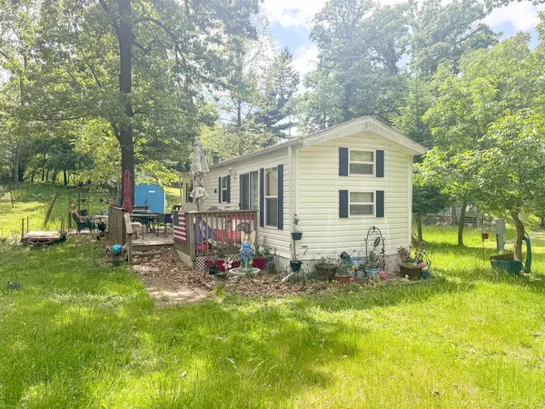 a view of backyard of house with wooden deck and seating space