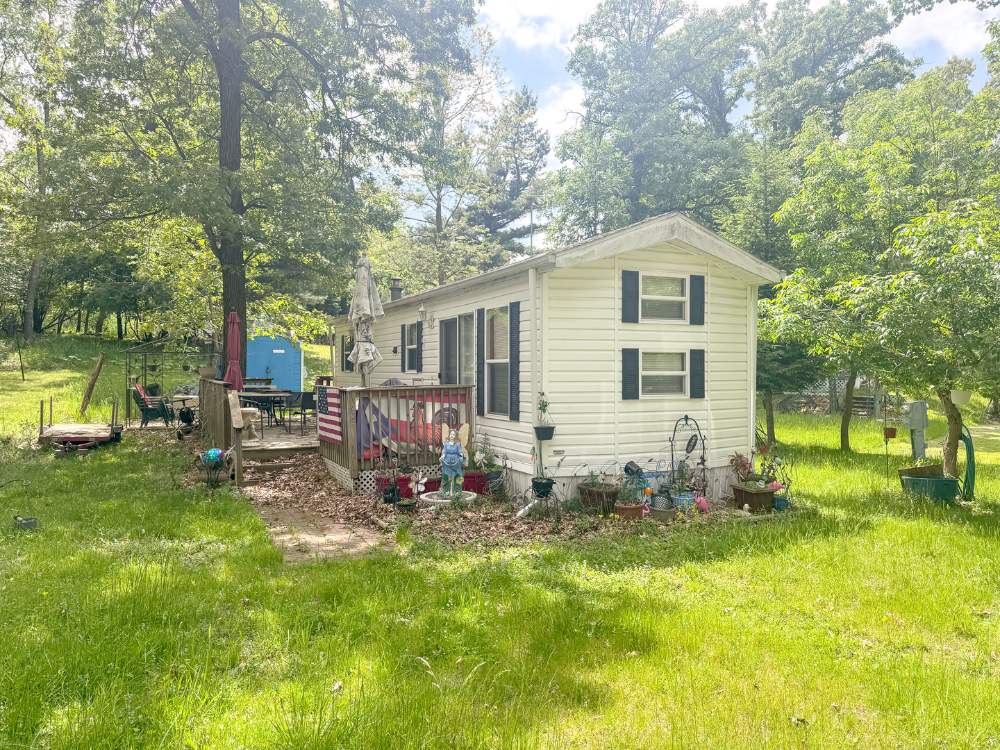 a view of backyard of house with wooden deck and seating space