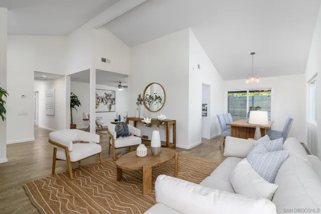 a living room with furniture a clock on wall and a table