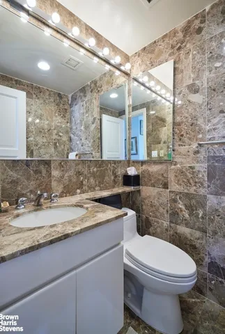 a bathroom with a granite countertop bathtub and toilet