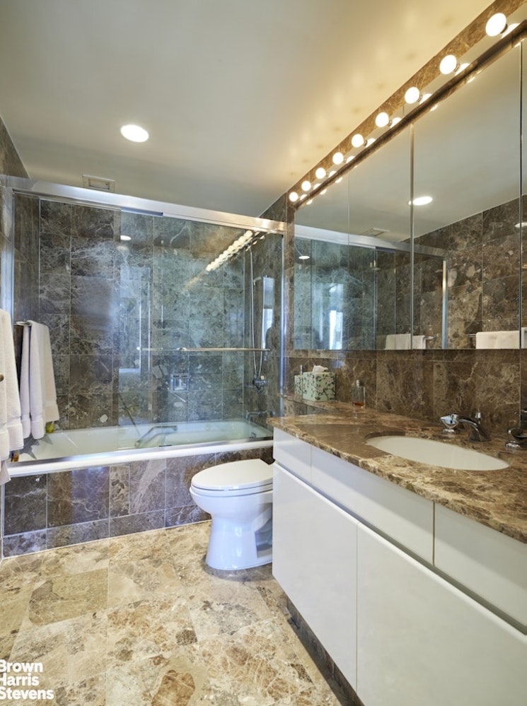 157 East 74th Street, Unit 10B Manhattan, NY 10021 - Photo 9 of 14 a bathroom with a granite countertop bathtub and toilet