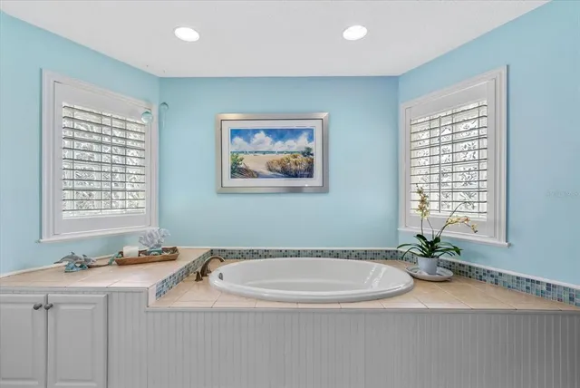 a kitchen with stainless steel appliances granite countertop a refrigerator a stove and white cabinets with wooden floors