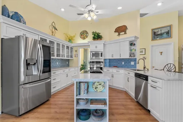 a kitchen with stainless steel appliances granite countertop a refrigerator and a stove top oven