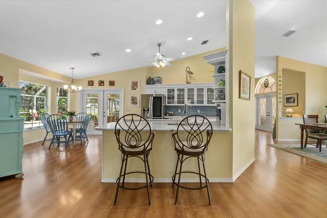 a kitchen with a sink dishwasher and white cabinets with wooden floor