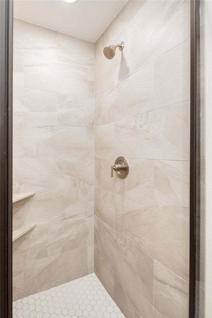 4700 Kensington Road Bryan, TX 77802 - Photo 18 of 31 Shower enclosure featuring large format light-toned tile walls and a hexagonal tile floor