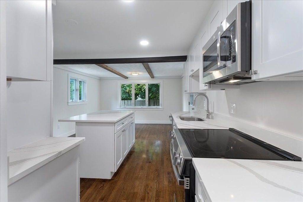 5 Rondeau Road Bellingham, MA 02019 - Photo 12 of 32 a kitchen with a sink dishwasher a stove and white cabinets with wooden floor