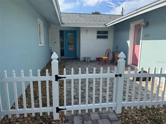 a view of a house with wooden fence