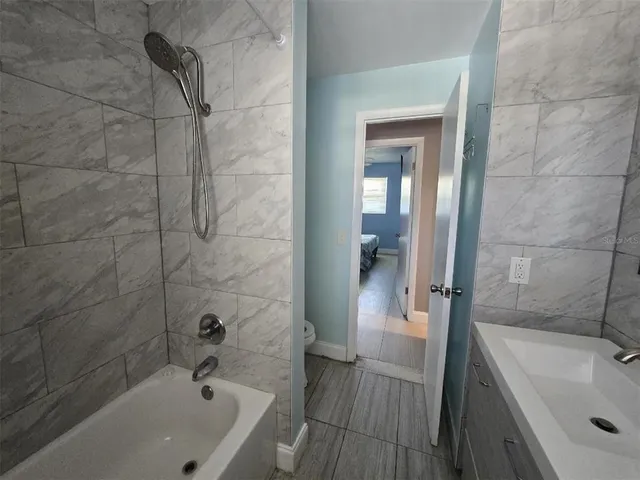 a bathroom with a tub a sink and shower