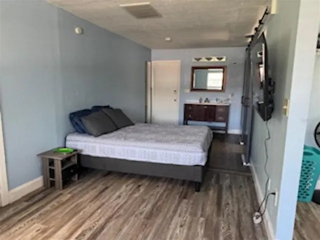 a bedroom with a bed window and wooden floor