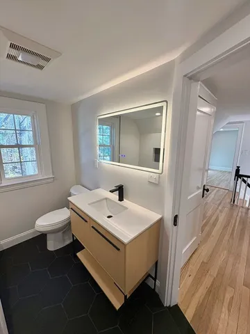 a bathroom with a sink toilet and mirror