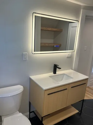 a bathroom with a toilet sink and mirror