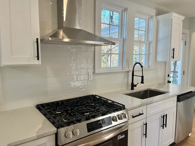 a kitchen with granite countertop a sink stove and cabinets