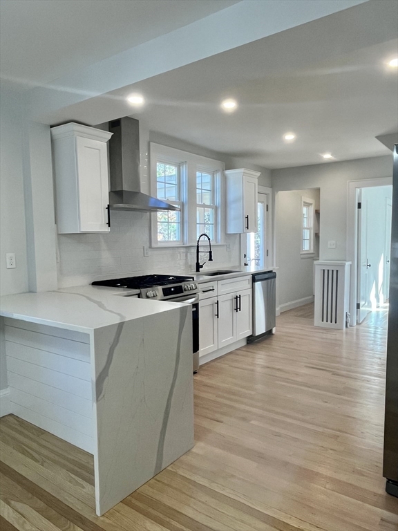 11 Park Lane Walpole, MA 02032 - Photo 7 of 27 a kitchen with stainless steel appliances granite countertop a stove top oven a sink dishwasher and white cabinets with wooden floor