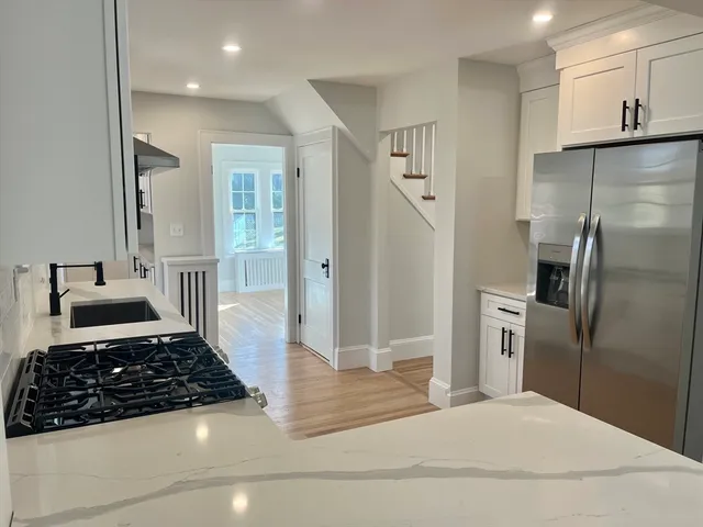 a kitchen with stainless steel appliances granite countertop a refrigerator and a stove
