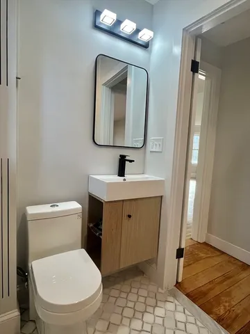 a bathroom with a toilet sink and mirror