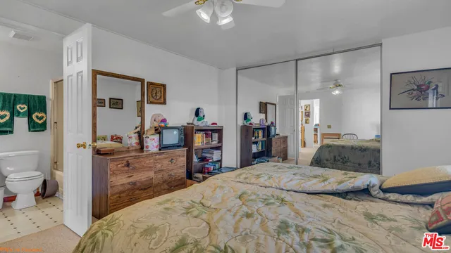 a bedroom with a bed and a dresser with mirror