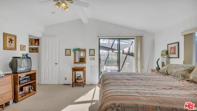 a bedroom with a bed window and a flat screen tv