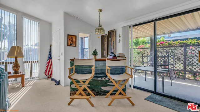 a dining room with furniture water view and a floor to ceiling window